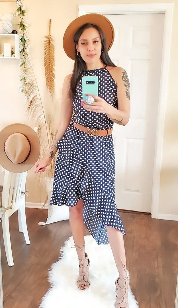 Woman in a polka dot midriff-baring outfit with a hat, taking a mirror selfie