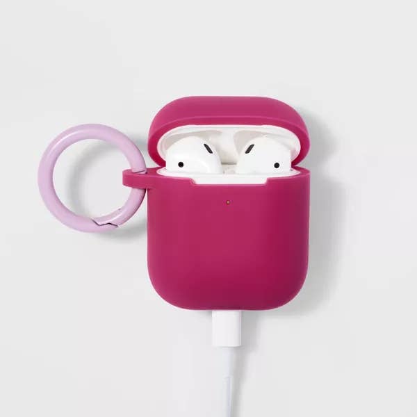 AirPods in the case in magenta attached to a cable