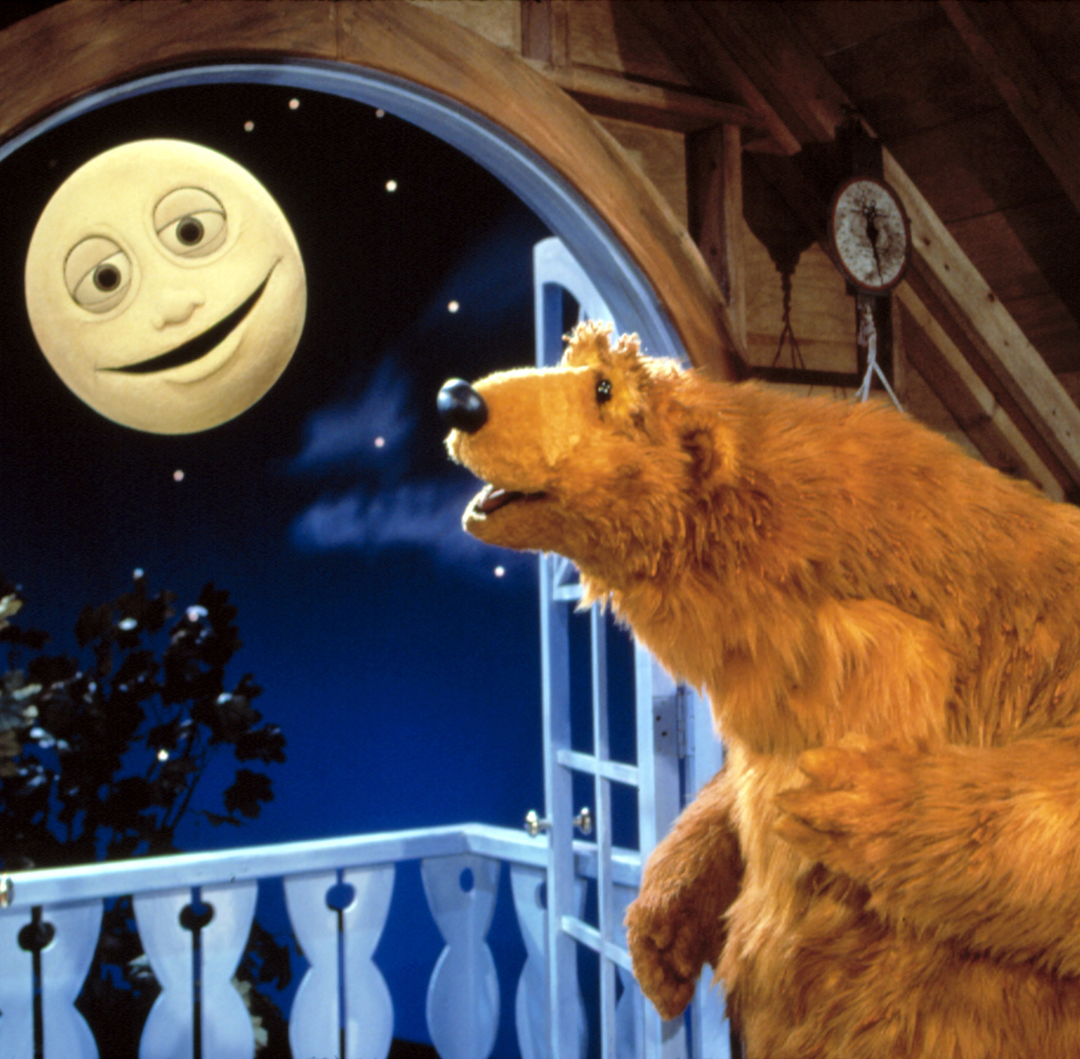 Bear in the Big Blue House character Bear stands by a window with Luna the moon outside