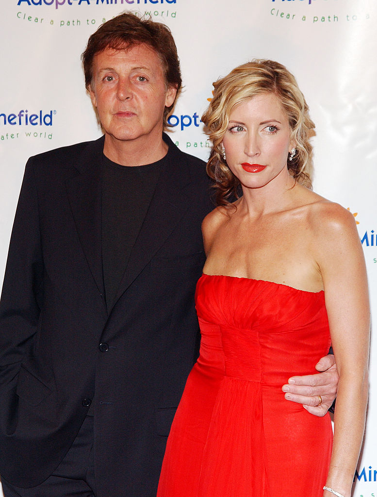 Paul McCartney and Heather Mills standing together, McCartney in a suit and Mills in a sleeveless gown