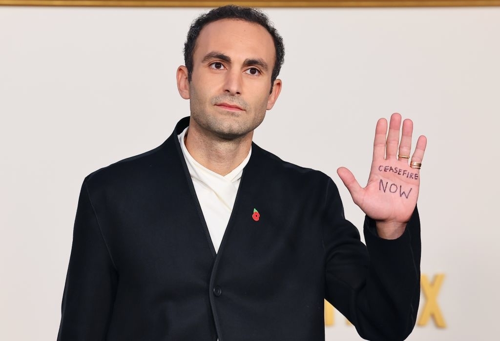 Khalid on the red carpet showing his palm with text that reads, &quot;ceasefire now&quot;