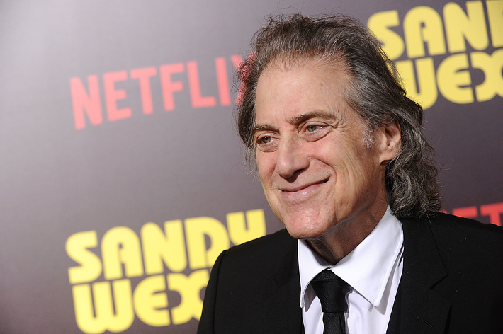 Richard Lewis in a black suit on the red carpet at the 'Sandy Wexler' premiere