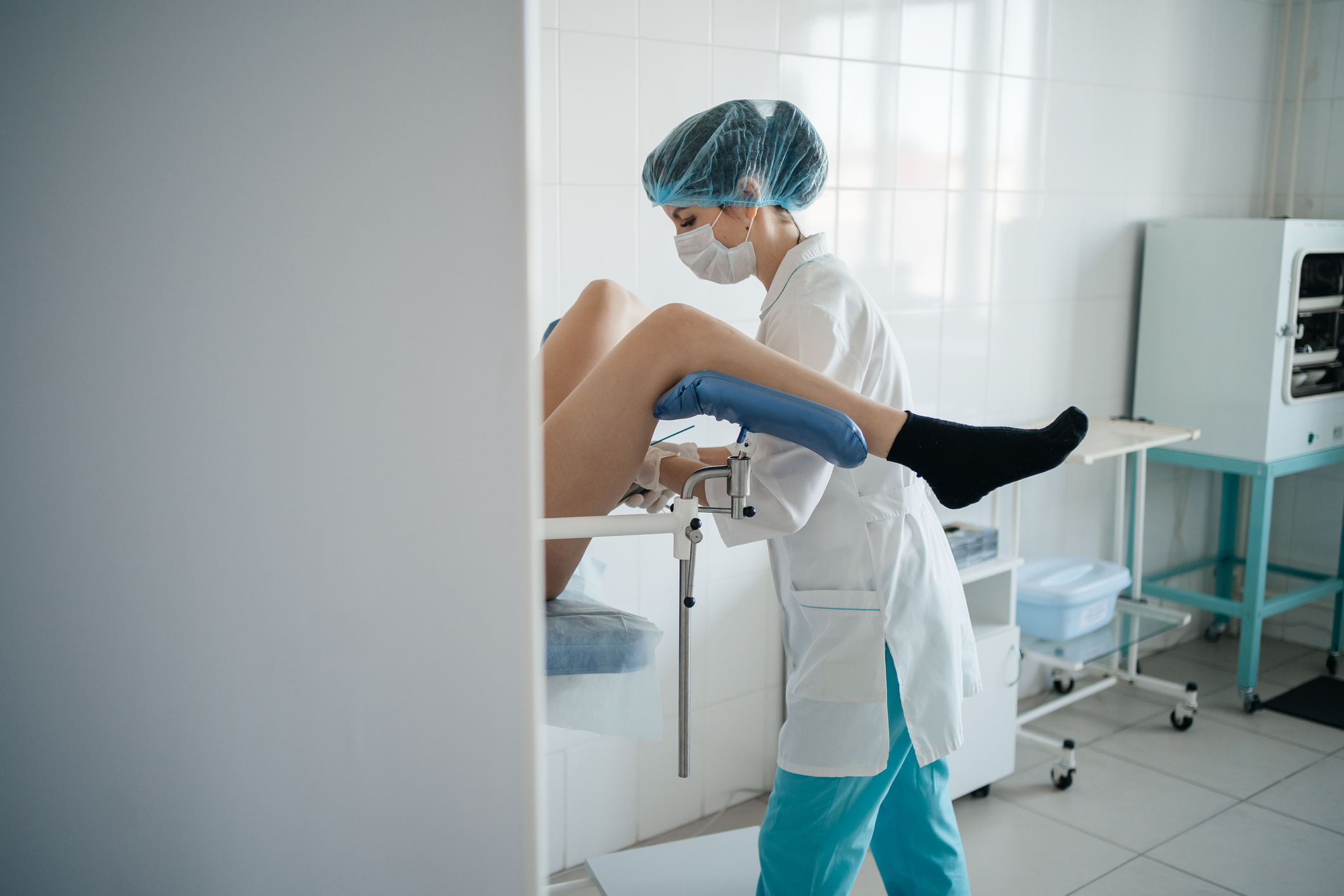 Medical professional conducting a gynecological exam on a patient in a clinic setup
