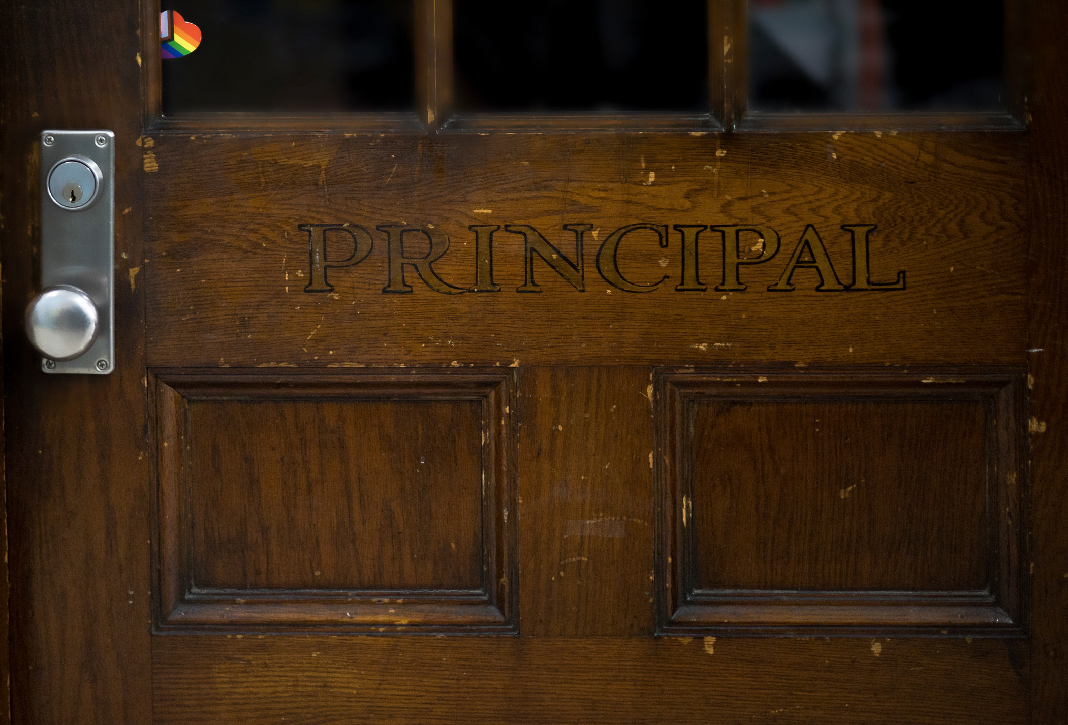 Wooden door with the word &quot;PRINCIPAL&quot; engraved on it and a security keypad to the side