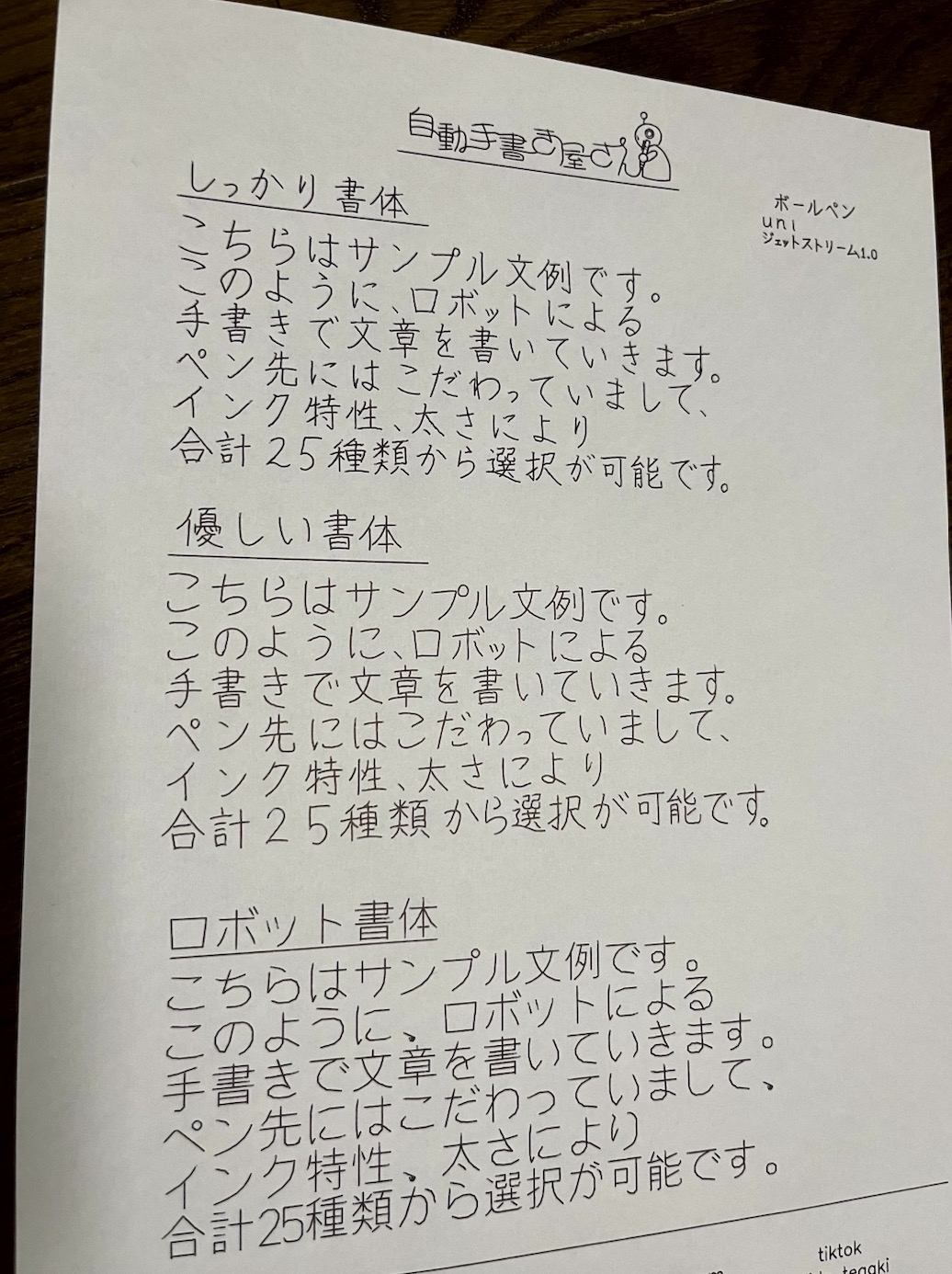 手書きロボットによる日本語メモがテーブルに置かれています。