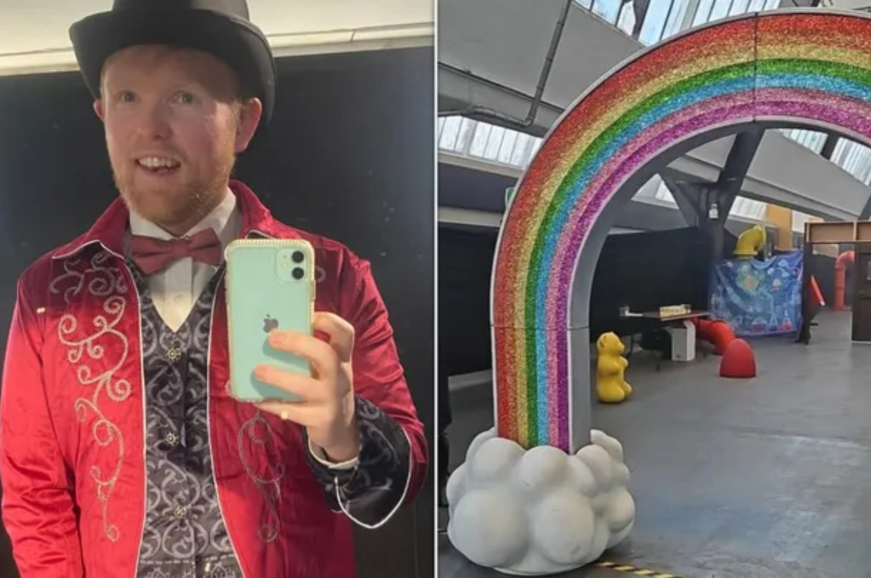 Man in a red patterned jacket taking a selfie; a rainbow arch and unusual sculptures in the background