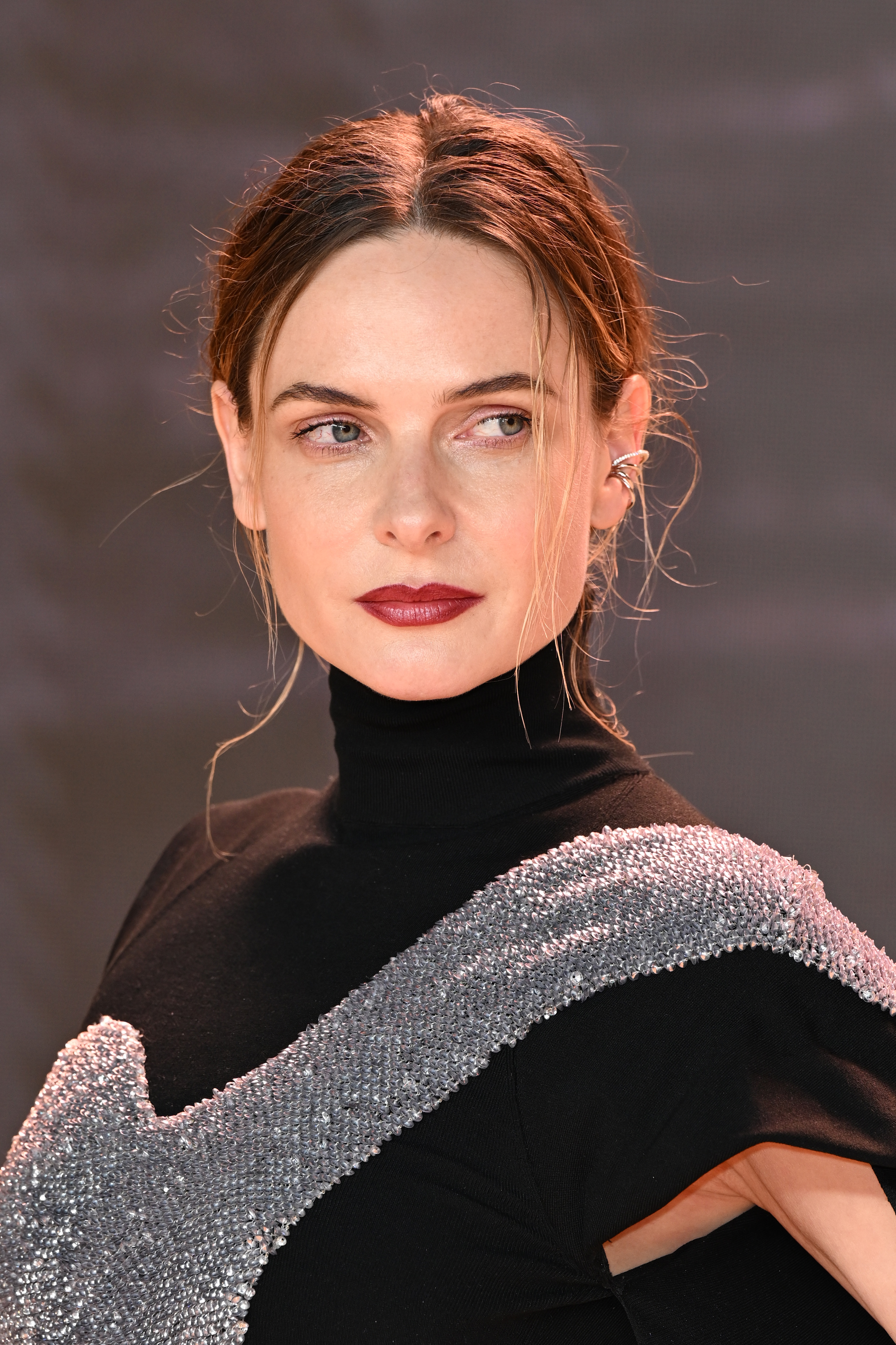 Rebecca in an outfit with a sparkling silver accent, looking to the side