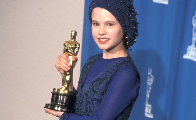 Woman in elegant dress holding an Oscar statuette