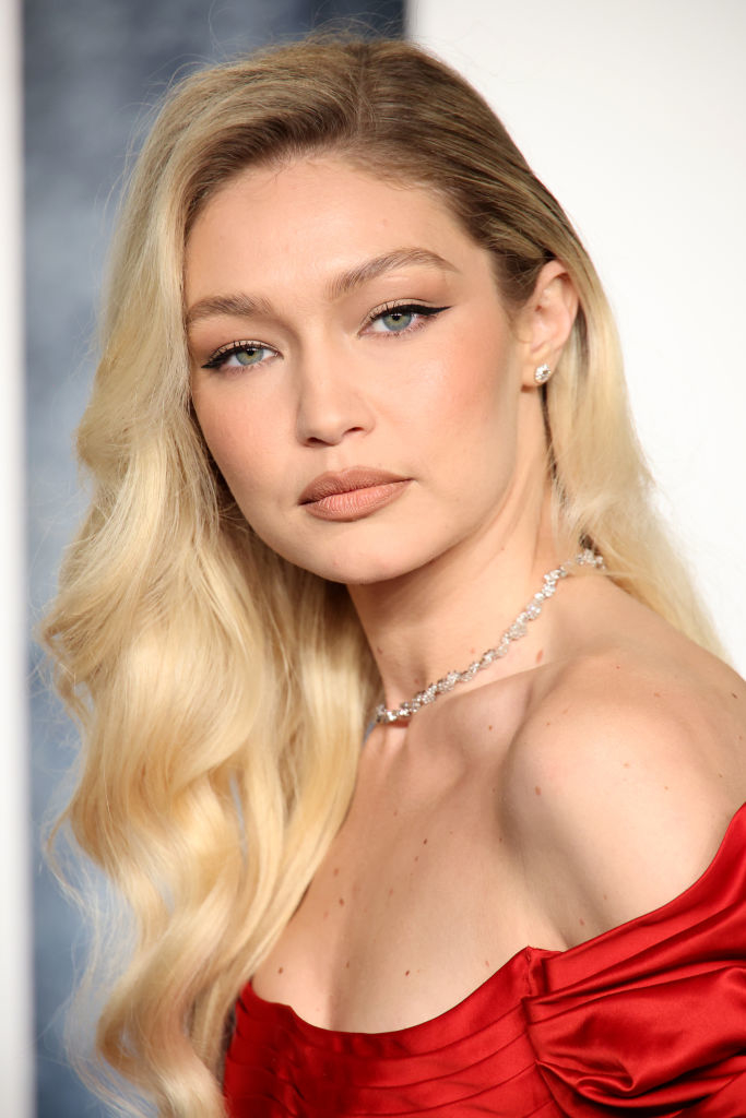 Gigi Hadid posing in an off-shoulder dress with a diamond necklace