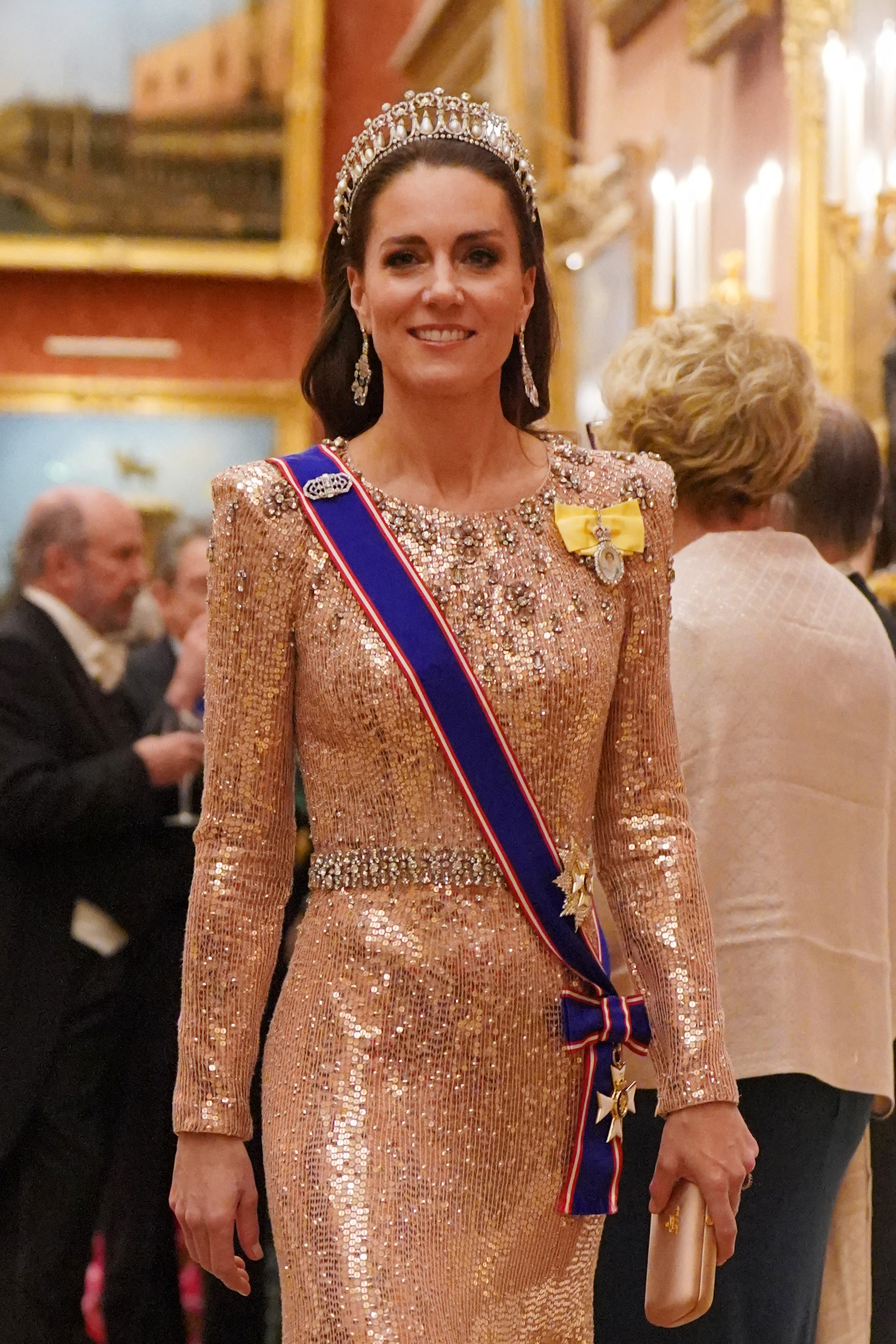 Kate Middleton in a glittery gown with a sash and tiara at a formal event
