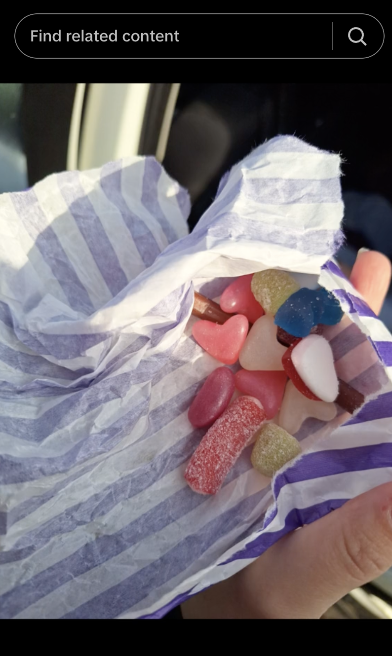 Hand holding a bag of various candies