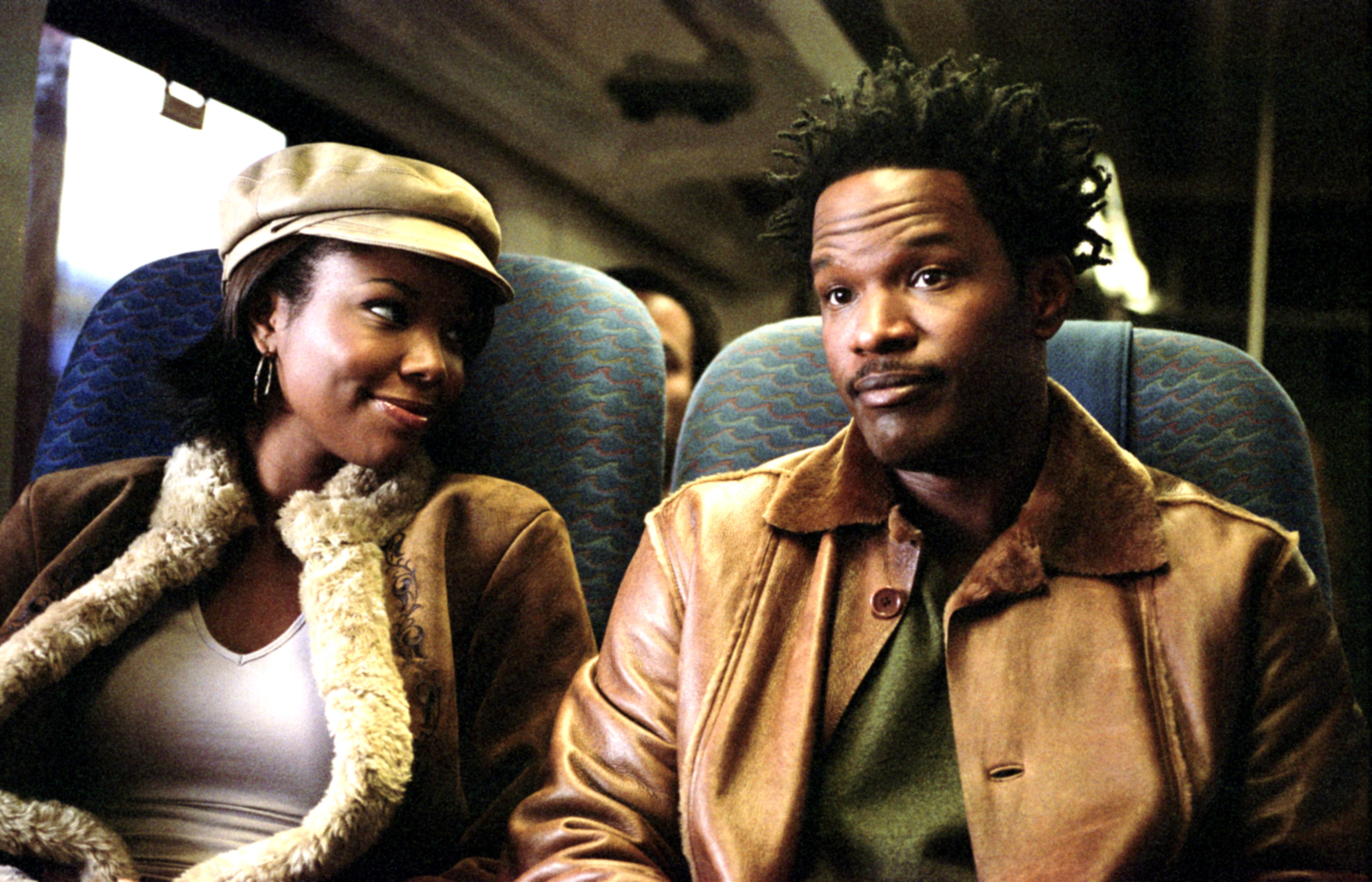 Gabrielle Union and Jamie Foxx sitting beside each other on a bus