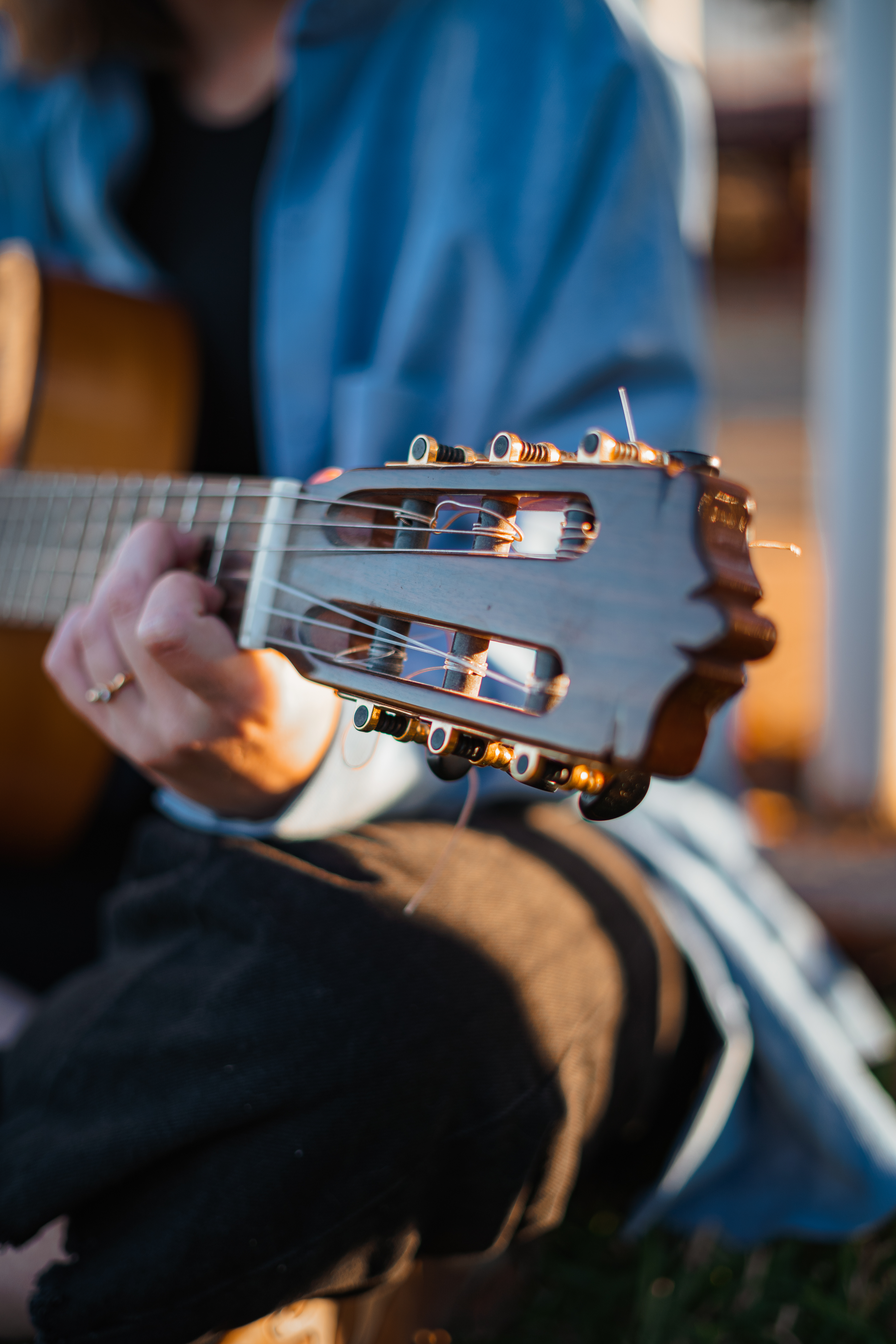 Close-up of a person&#x27;s hands tuning an acoustic guitar