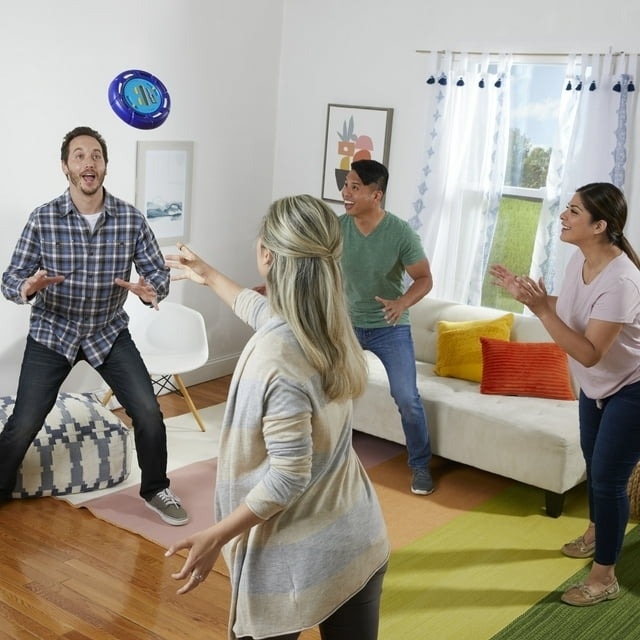 Four people playing with a game indoors