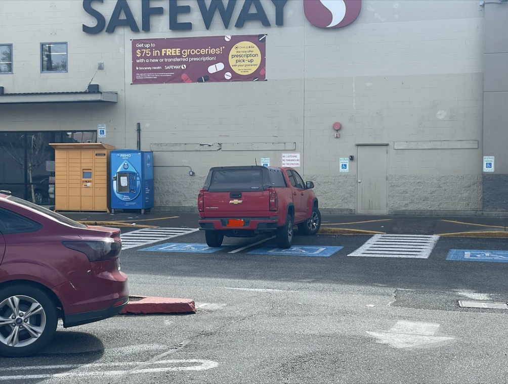 Pickup truck parked across multiple designated parking spots in a lot