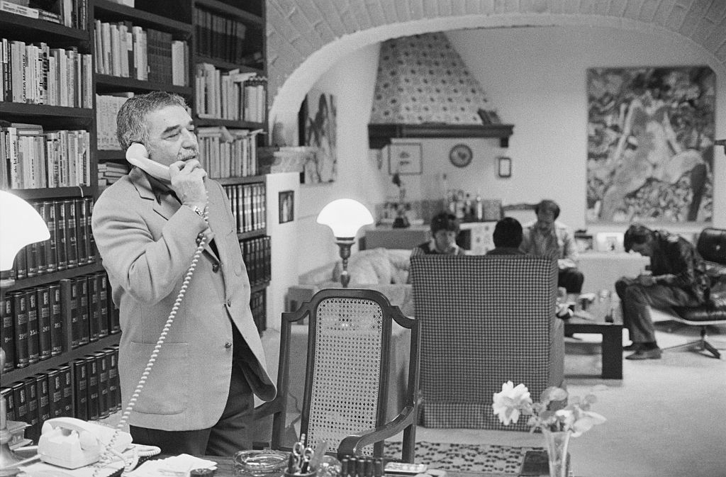 Man on phone in a library with people in background