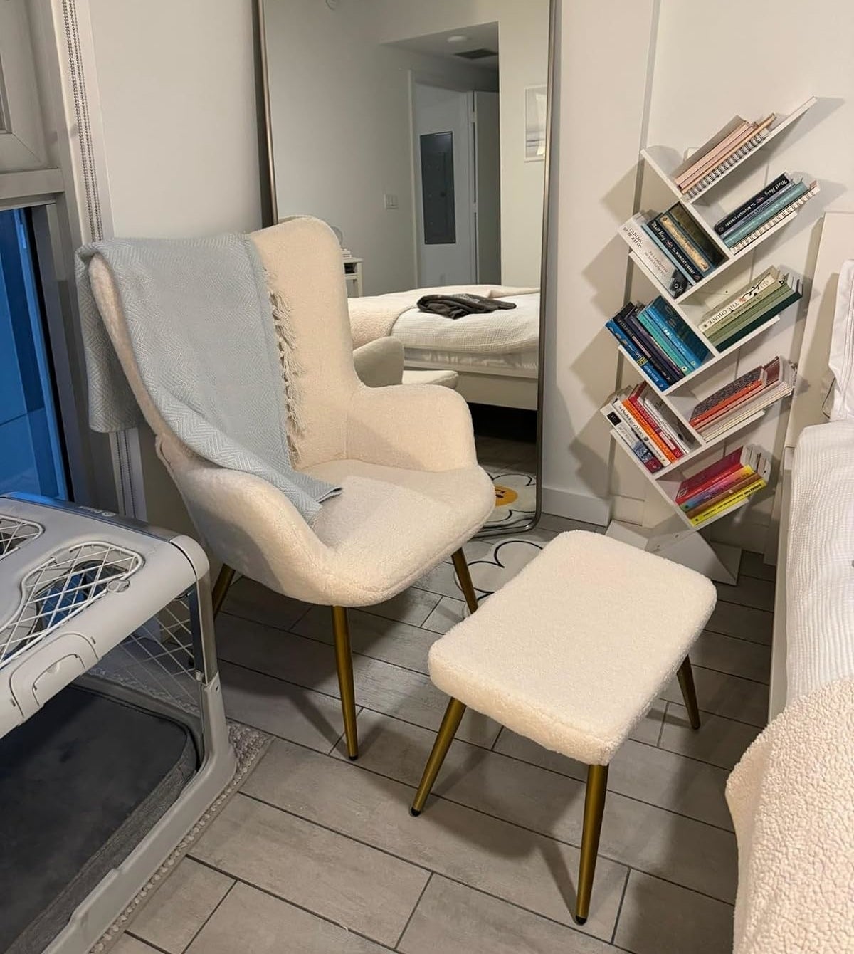 Modern style chair and footrest with gold legs in a cozy reading corner, next to a full bookshelf