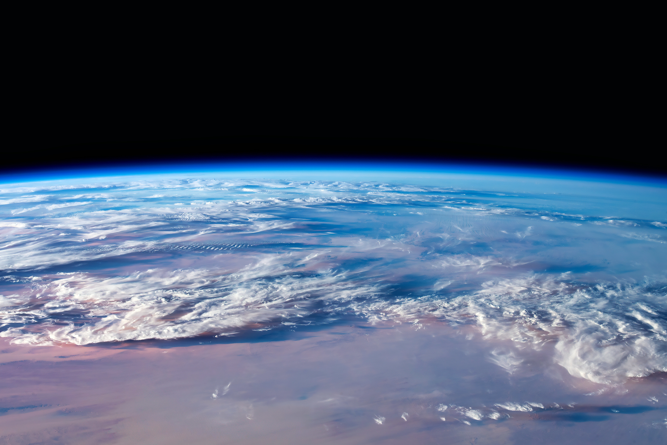 Earth&#x27;s curved horizon with clouds and land from space