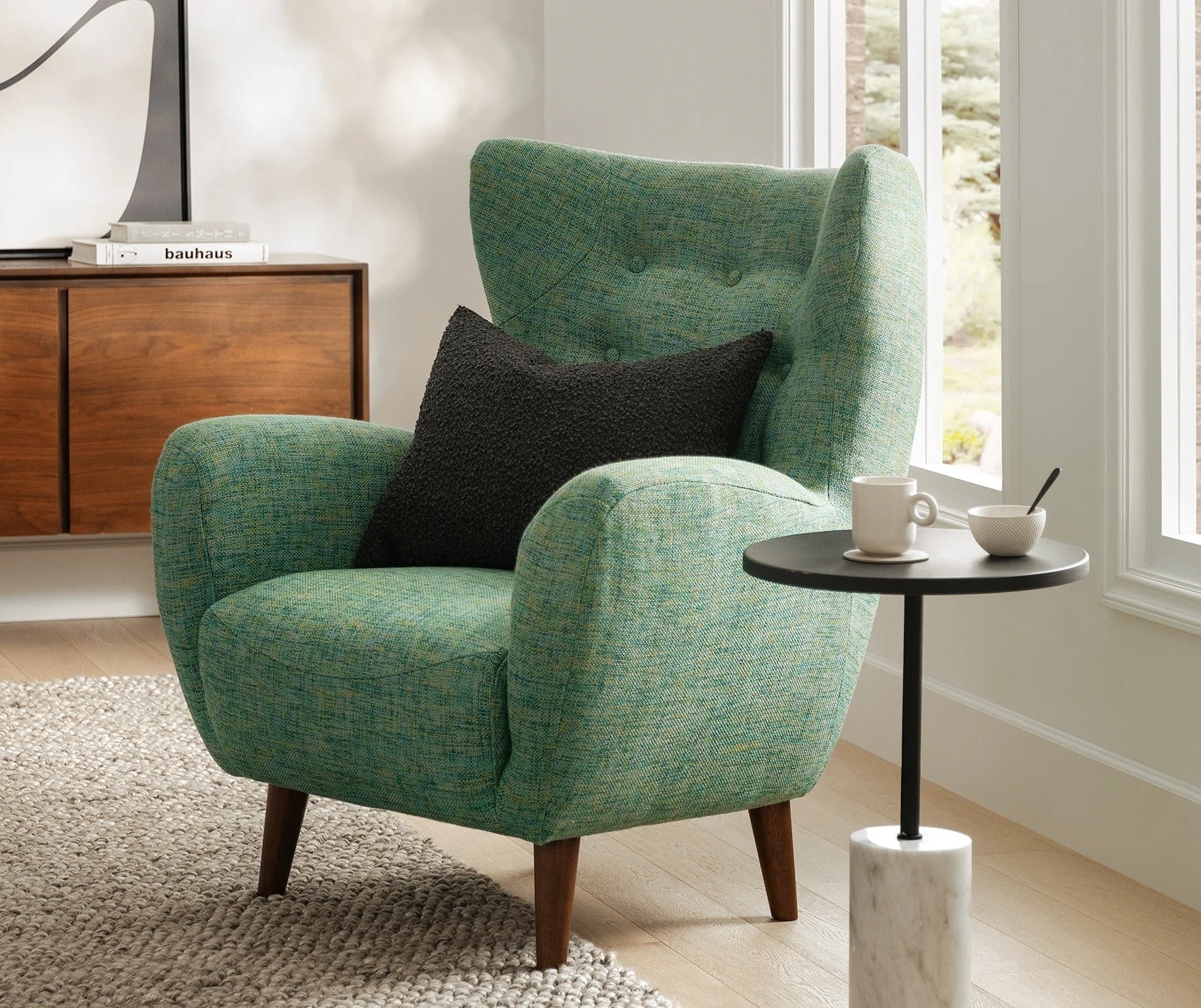 Textured armchair with a side table displaying a tea set in a well-lit, cozy room setup
