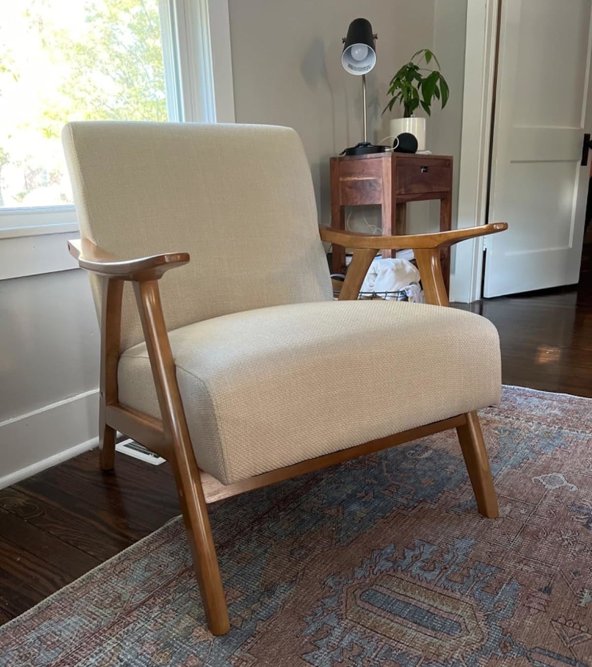 Mid-century modern style armchair with wooden frame in a home setting