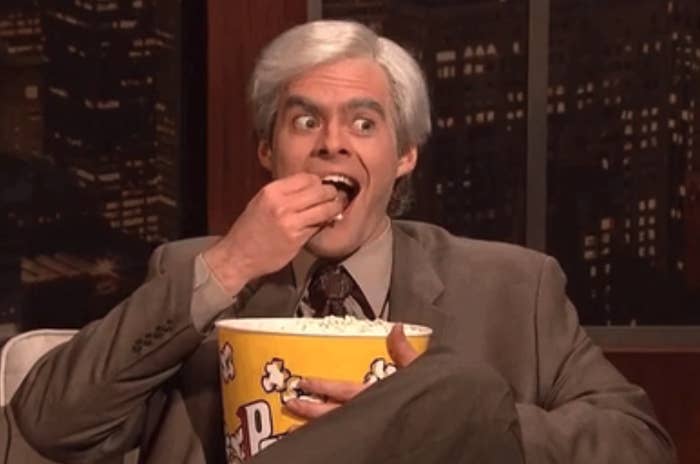 Bill Hader as Stefon from SNL, eating popcorn, with a surprised expression