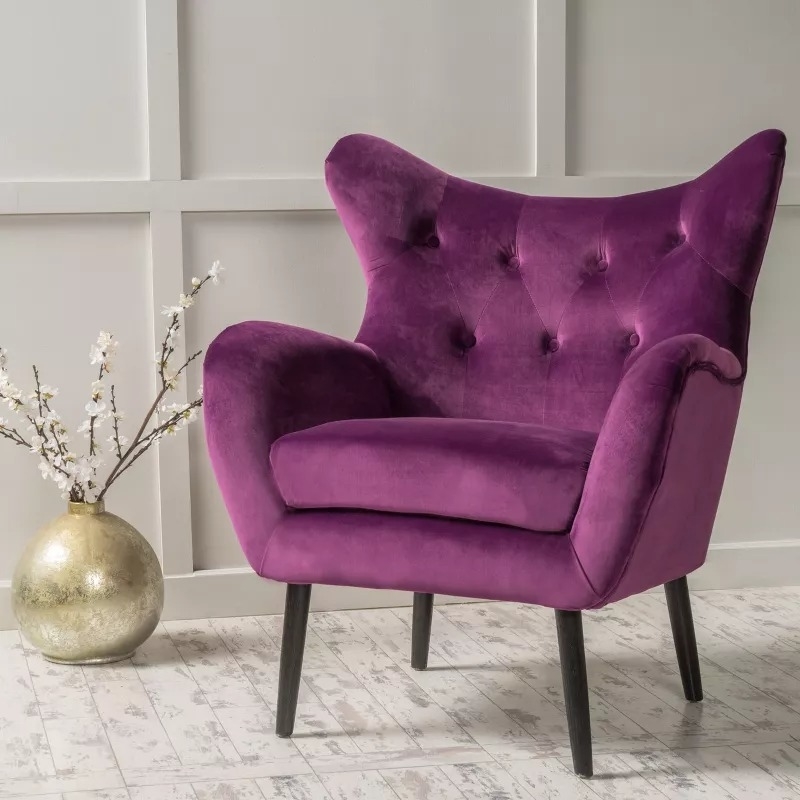 Modern tufted wingback chair in a home setting with a decorative vase