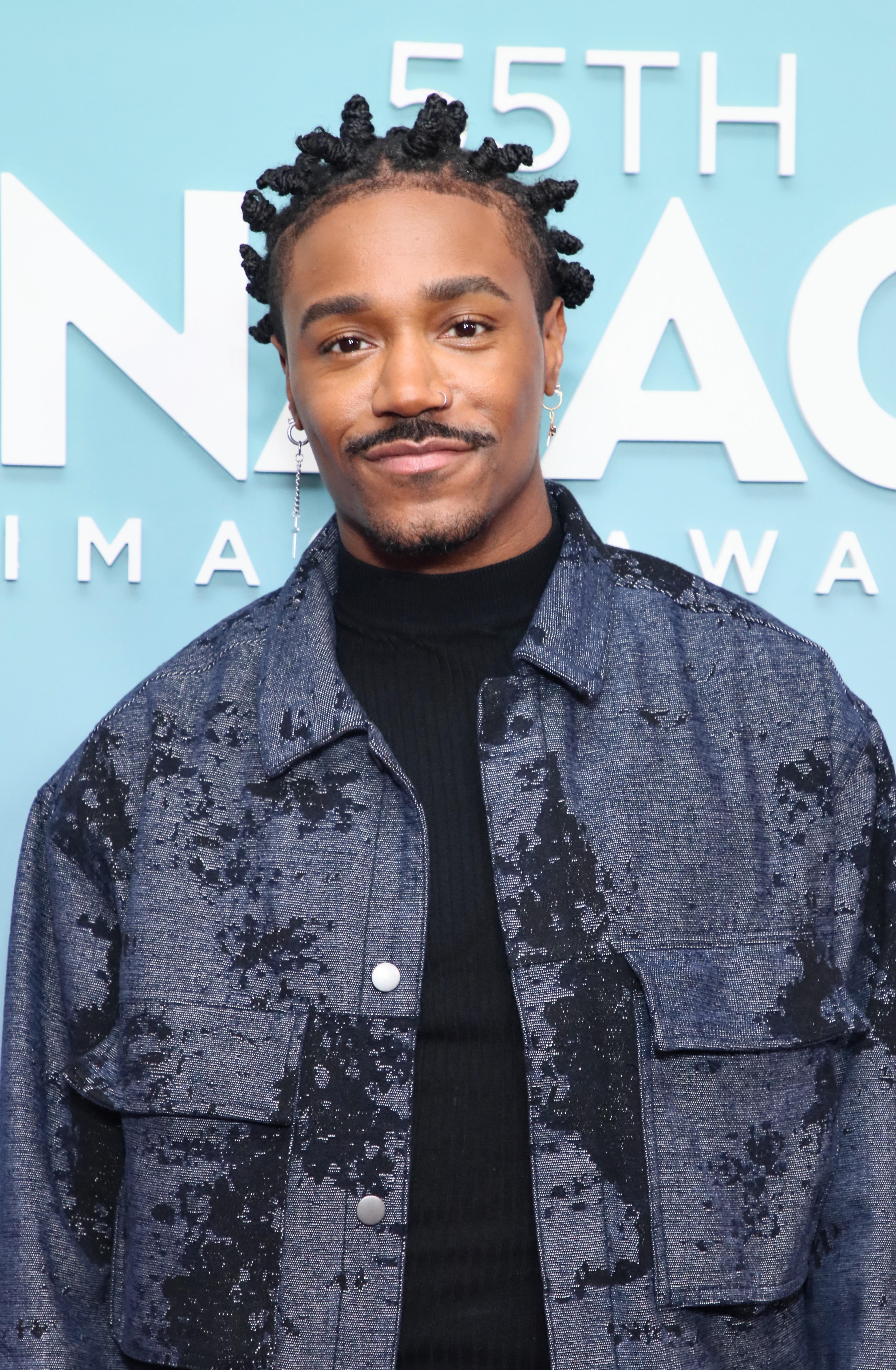 Dewayne rocks bantu knots while wearing in a turtleneck and textured denim jacket on the NAACP Image Awards red carpet
