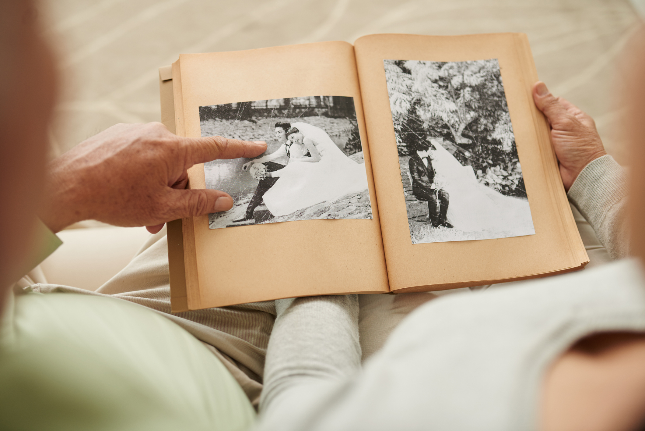 Two people viewing a photo album with a vintage wedding picture