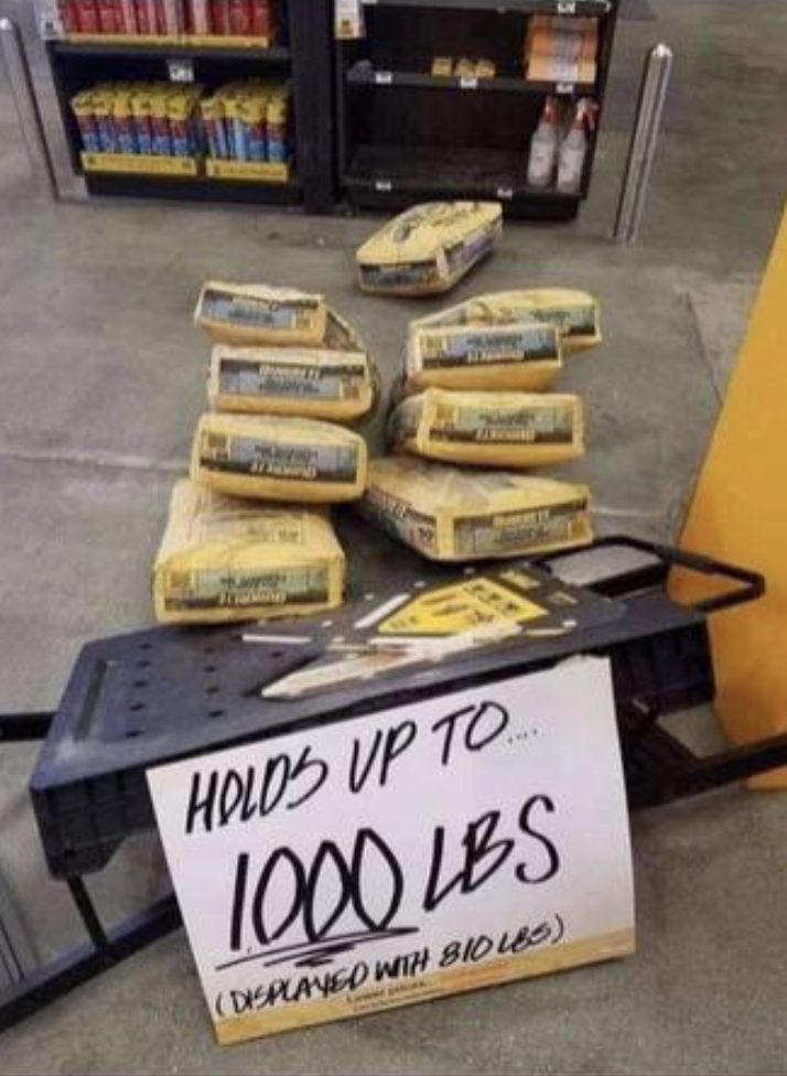 Sign reads &quot;Holds up to 1000 lbs&quot; next to a collapsed table with several bags that were on it