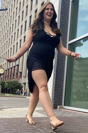 a reviewer in a black dress wearing the nude heels, walking through new orleans