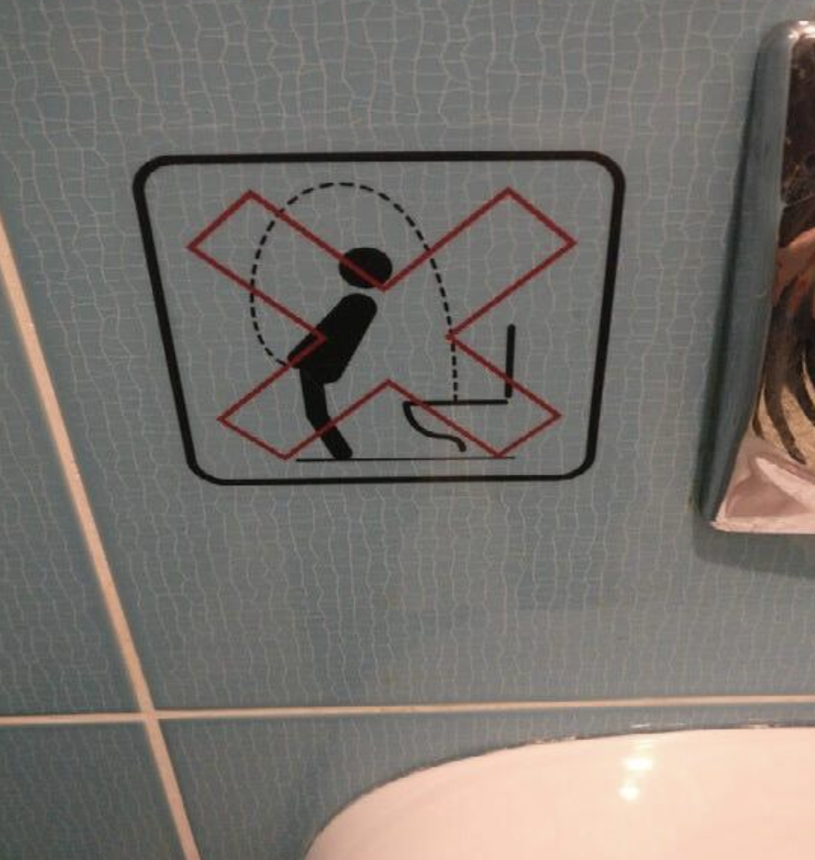 Sign depicting no drinking from toilet with a stick figure and a red cross over it
