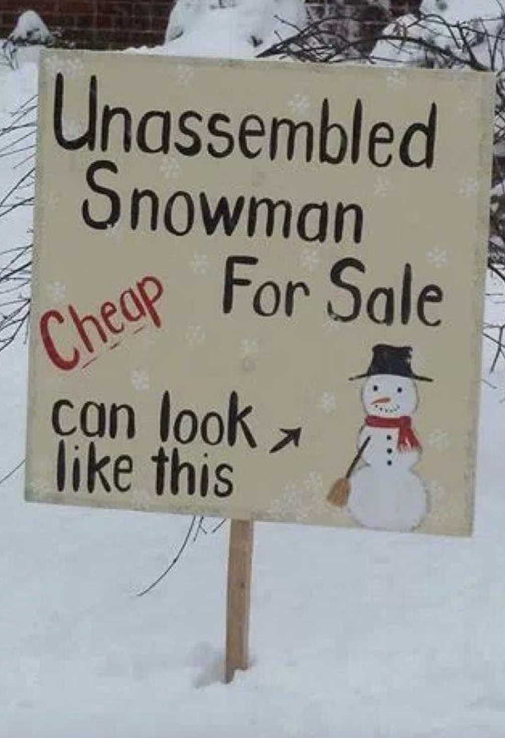Sign reads &quot;Unassembled Snowman for Sale&quot; with an arrow pointing to snow and a drawing of a snowman for reference