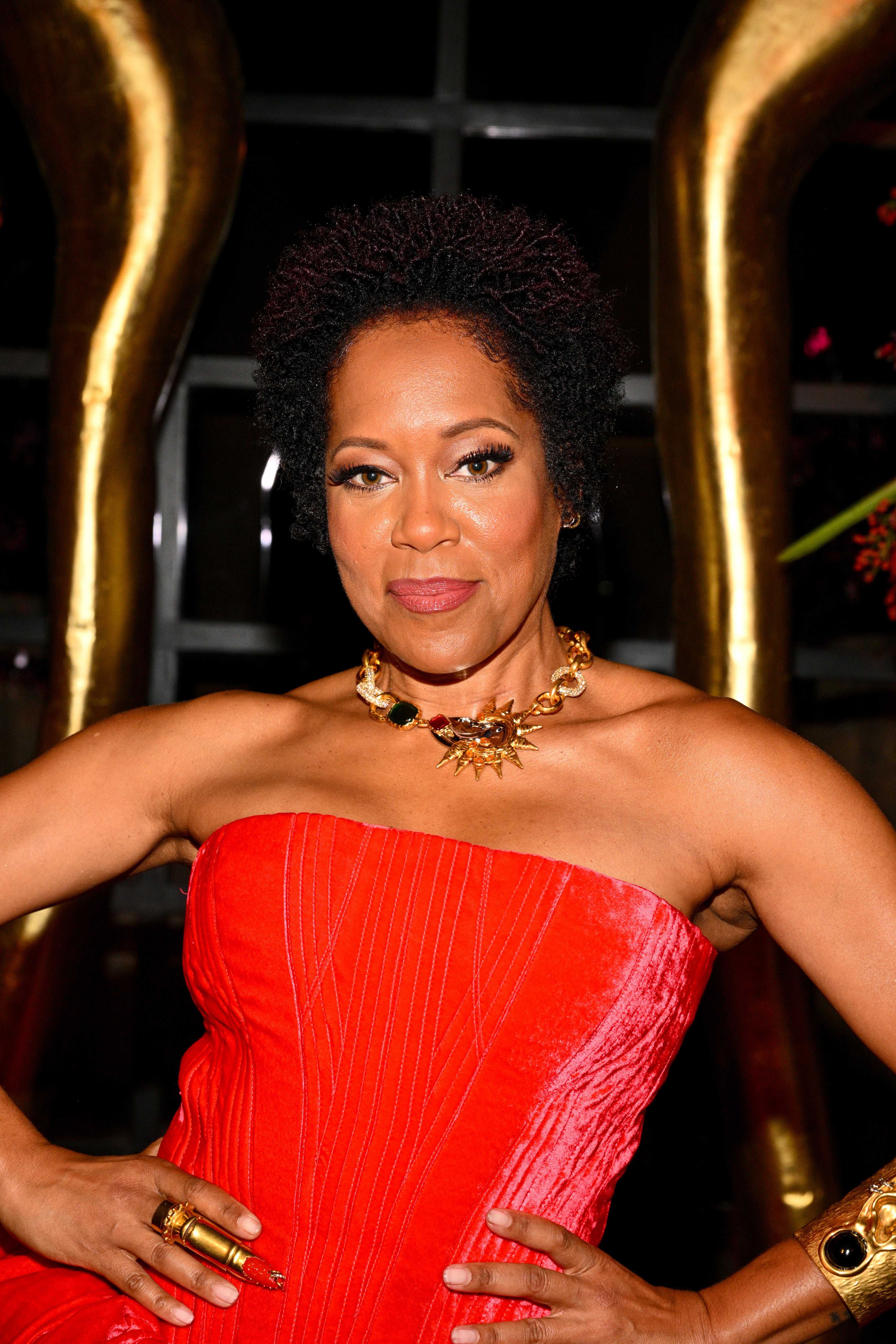 Closeup of Regina King posing for the camera with her hand on her hips