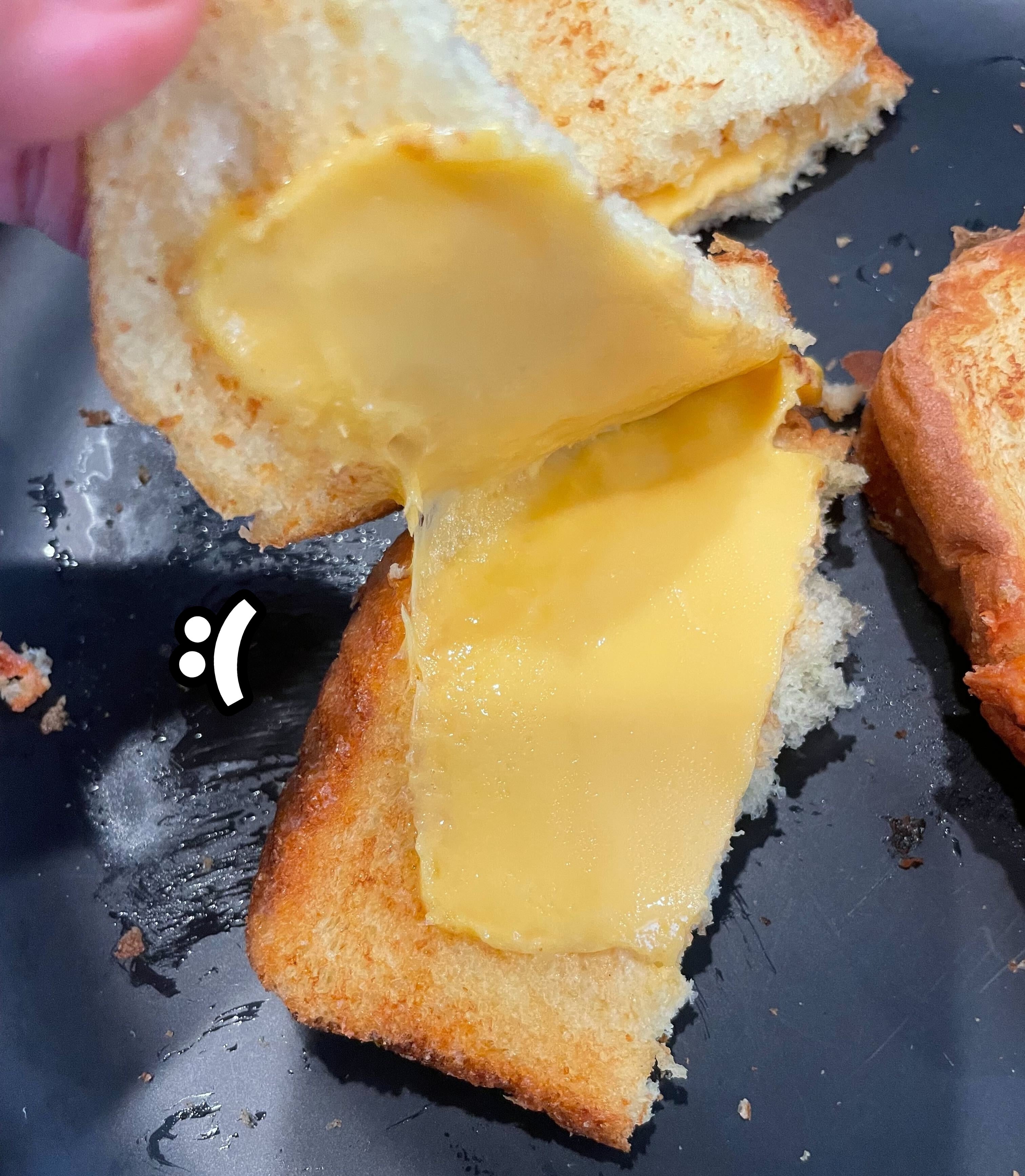 Grilled cheese sandwich on a plate, cut open with only slightly melted cheese