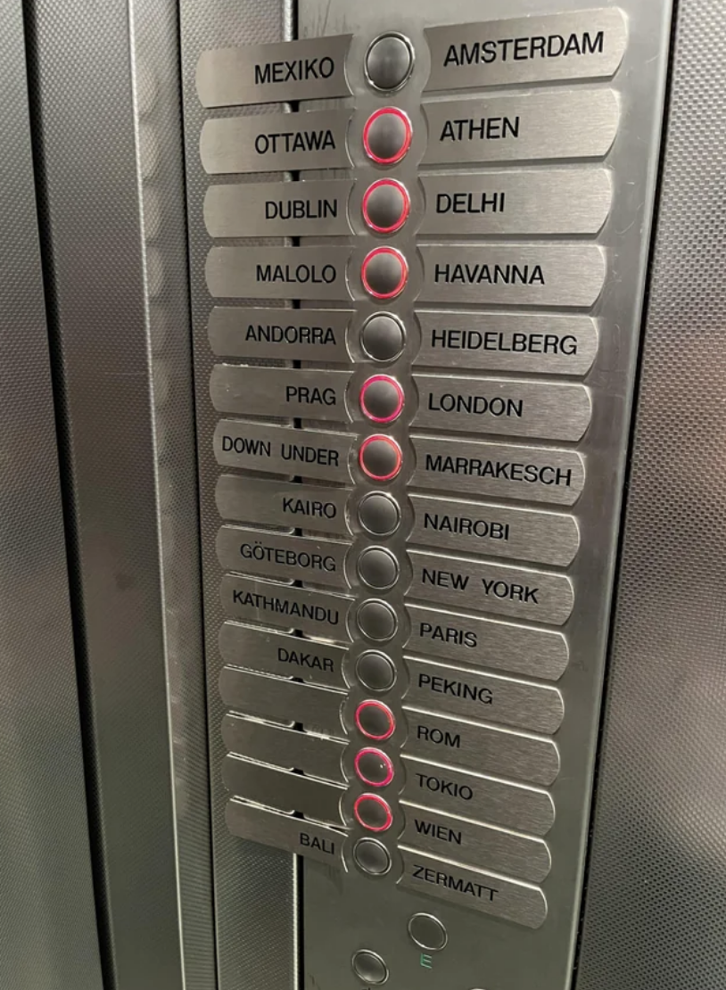 Elevator panel with buttons for cities around the world, such as Mexico, Tokyo, and New York, instead of floor numbers