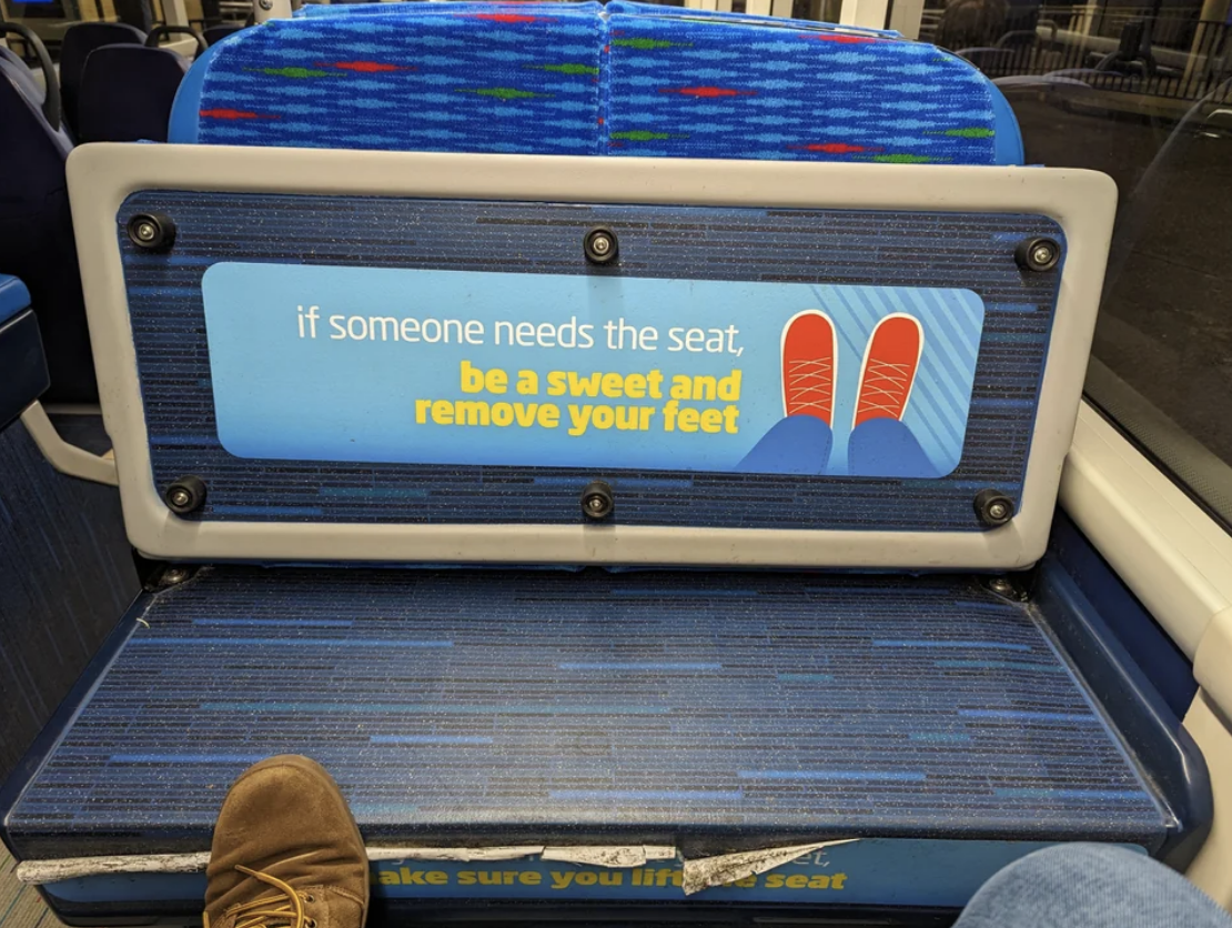 Sign on bus seat reads &quot;if someone needs the seat, be a sweet and remove your feet&quot; with a graphic of shoes on a seat