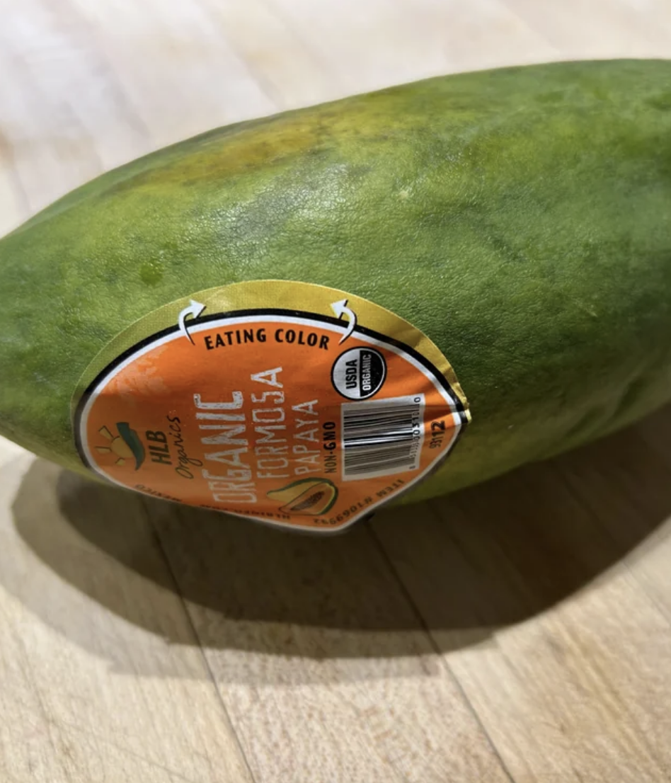 Close-up of a sticker on a papaya with the words &quot;Organic, Eating Color&quot; and a UPC code