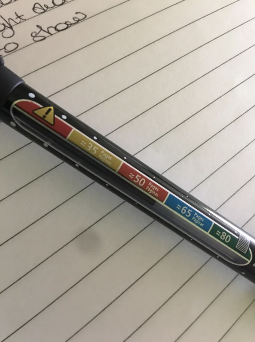 A pen with multiple-choice buttons displaying exam answer options from A to E on lined notebook paper