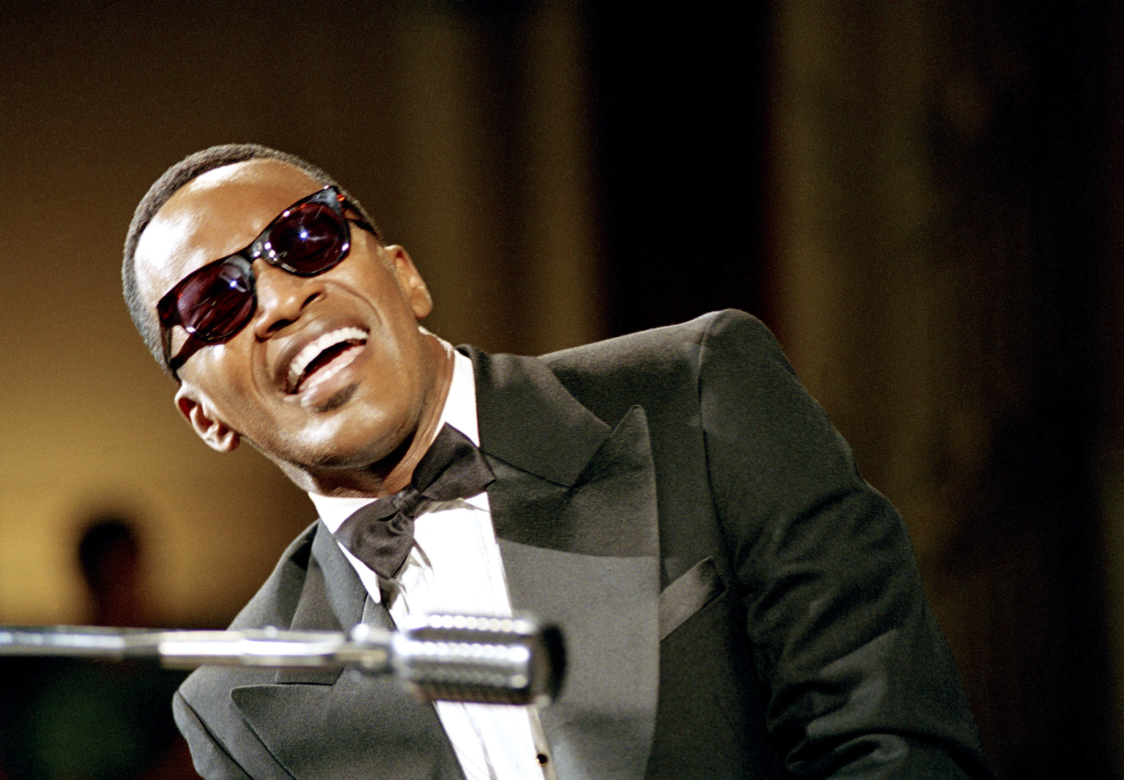 Jamie Foxx in a tuxedo playing the piano and singing