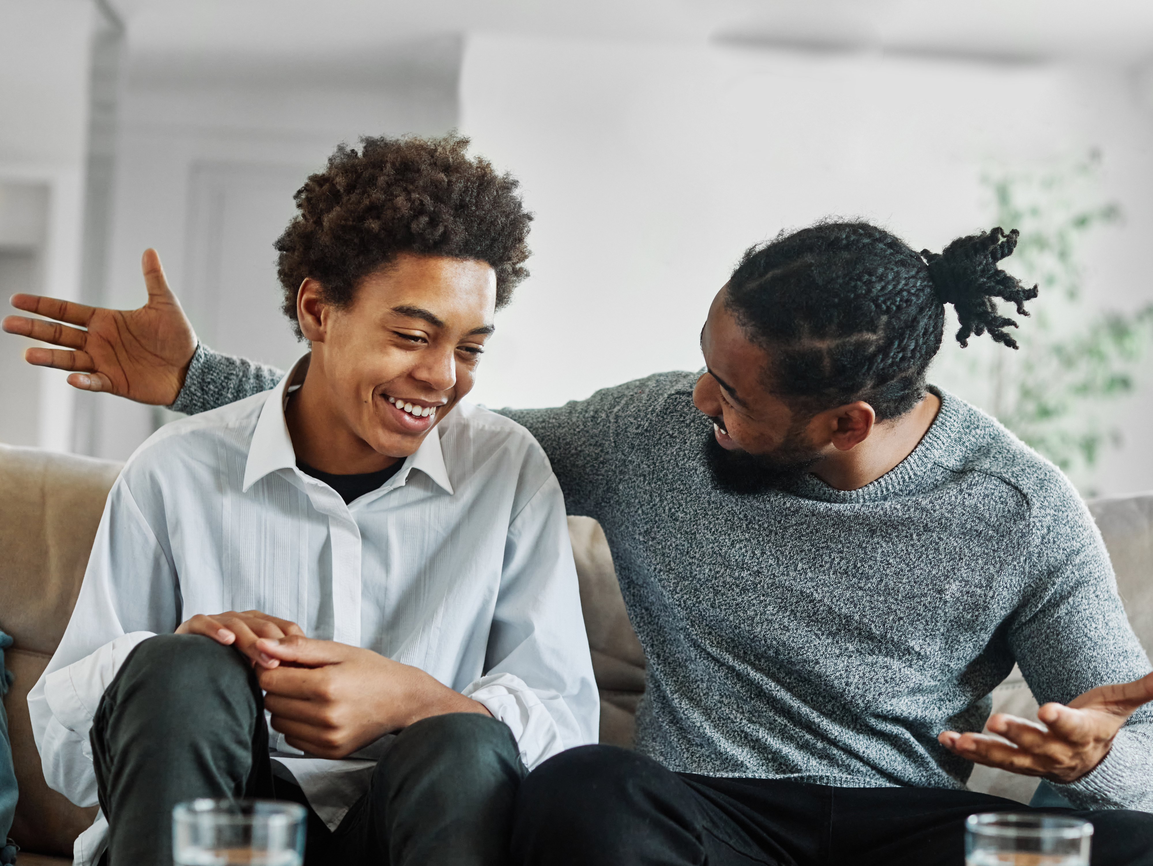Two people having a cheerful conversation on a couch