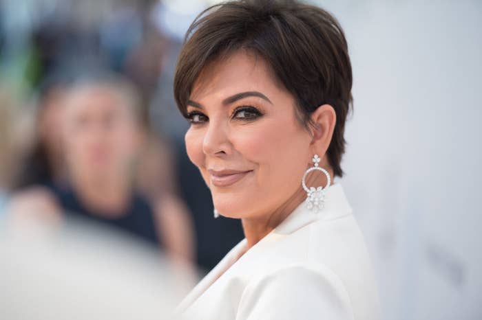 A close-up of Kris Jenner smiling at the camera with a focus on her large hoop earrings