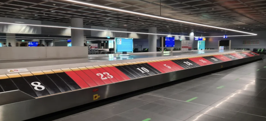 Baggage claim area at an airport with conveyor belts and numbered stations