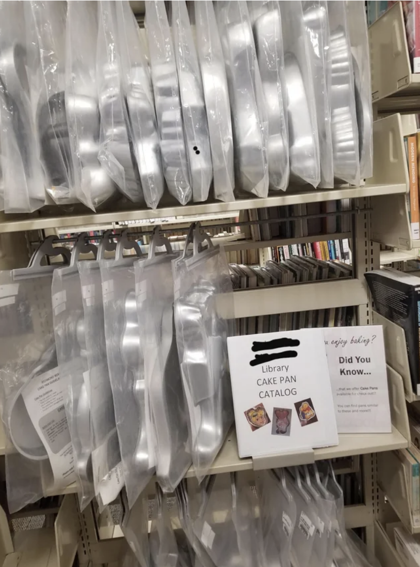 Shelves stocked with cake pan sets, sign reads "Library Cake Pan Catalog" and informational flyer