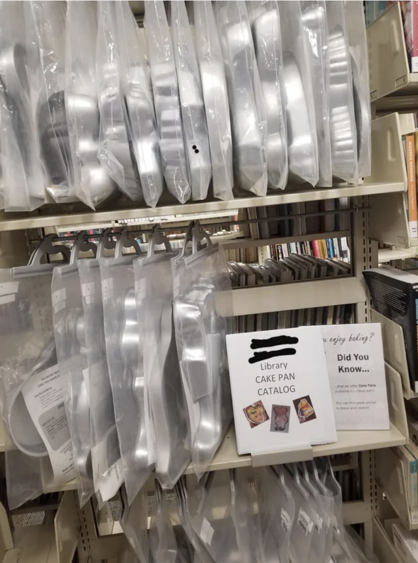 Shelves stocked with cake pan sets, sign reads &quot;Library Cake Pan Catalog&quot; and informational flyer