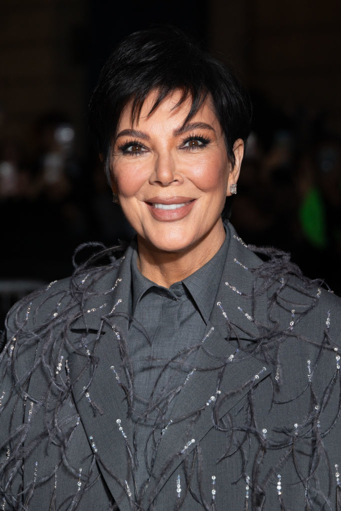 Kris Jenner smiling, wearing an embellished, fringed jacket