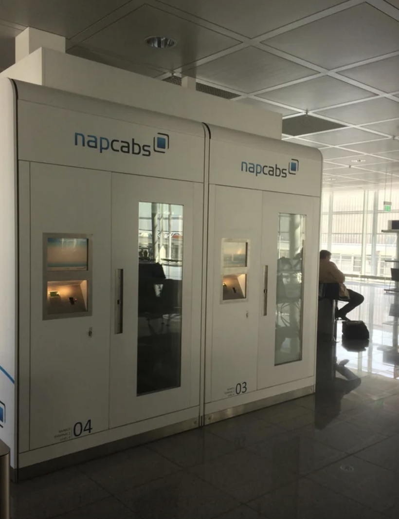Private sleeping pods, labeled &quot;napcabs,&quot; in an airport lounge