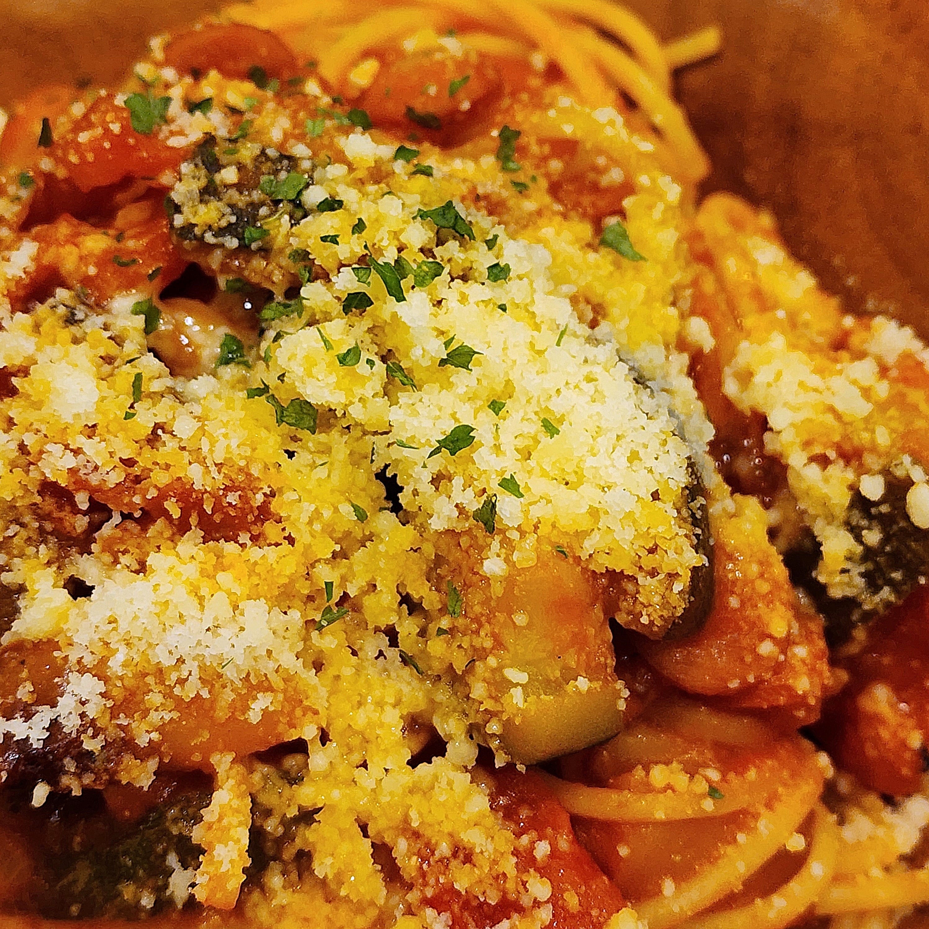 スパゲッティにトマトベースのソースとパルメザンチーズがかかっています。