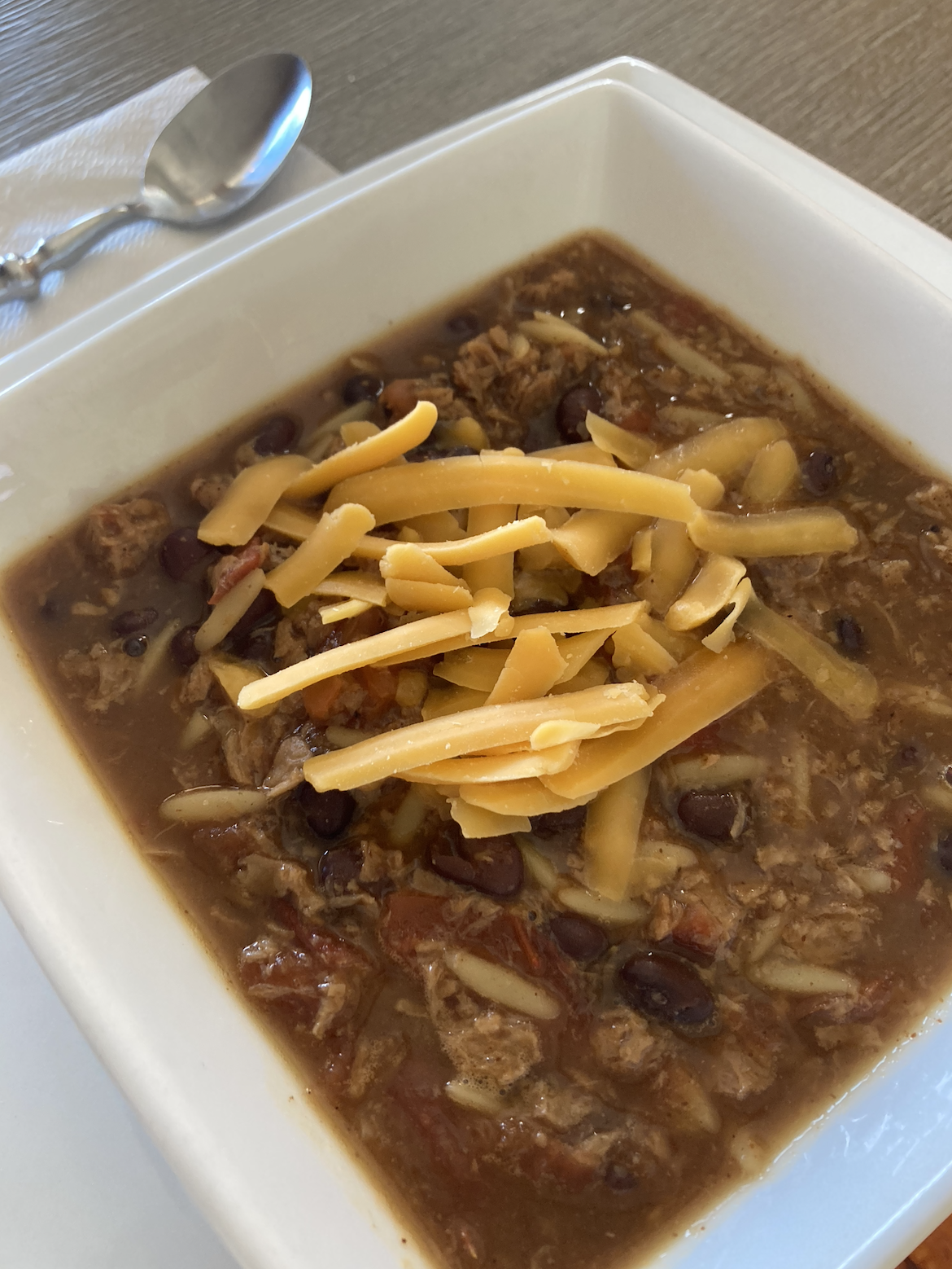 a bowl of chili with cheese on top