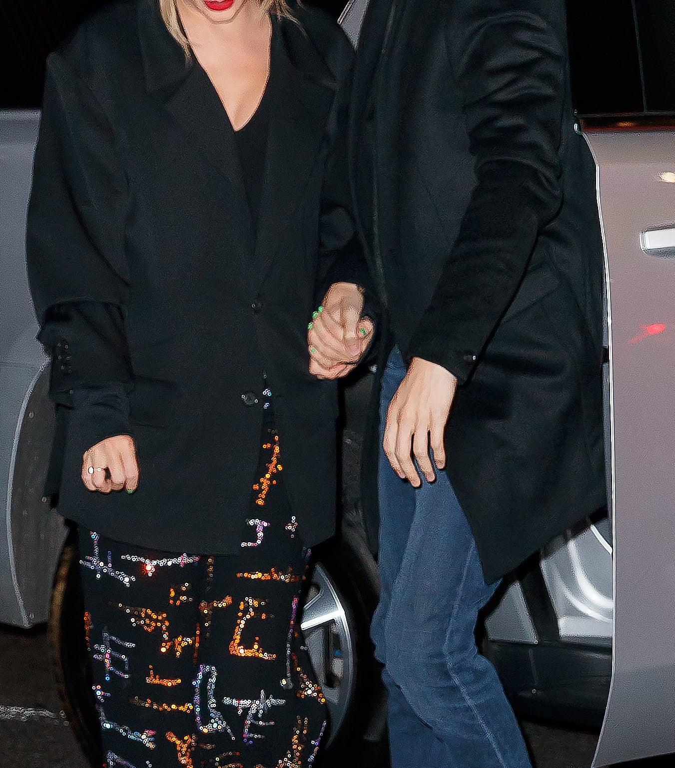 Close-up of Taylor and Joe holding hands as they exit a car