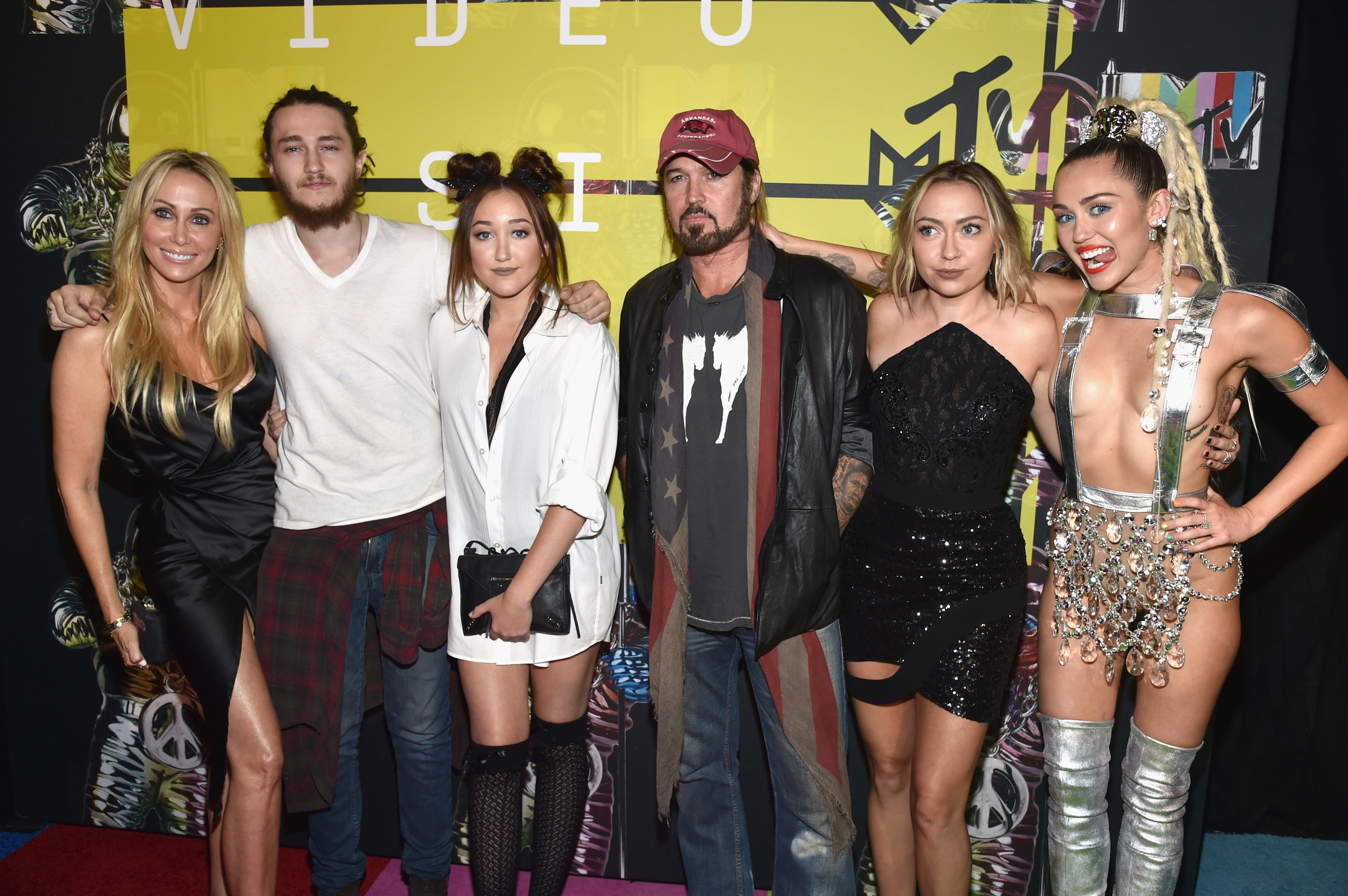 The Cyrus family standing together on the red carpet